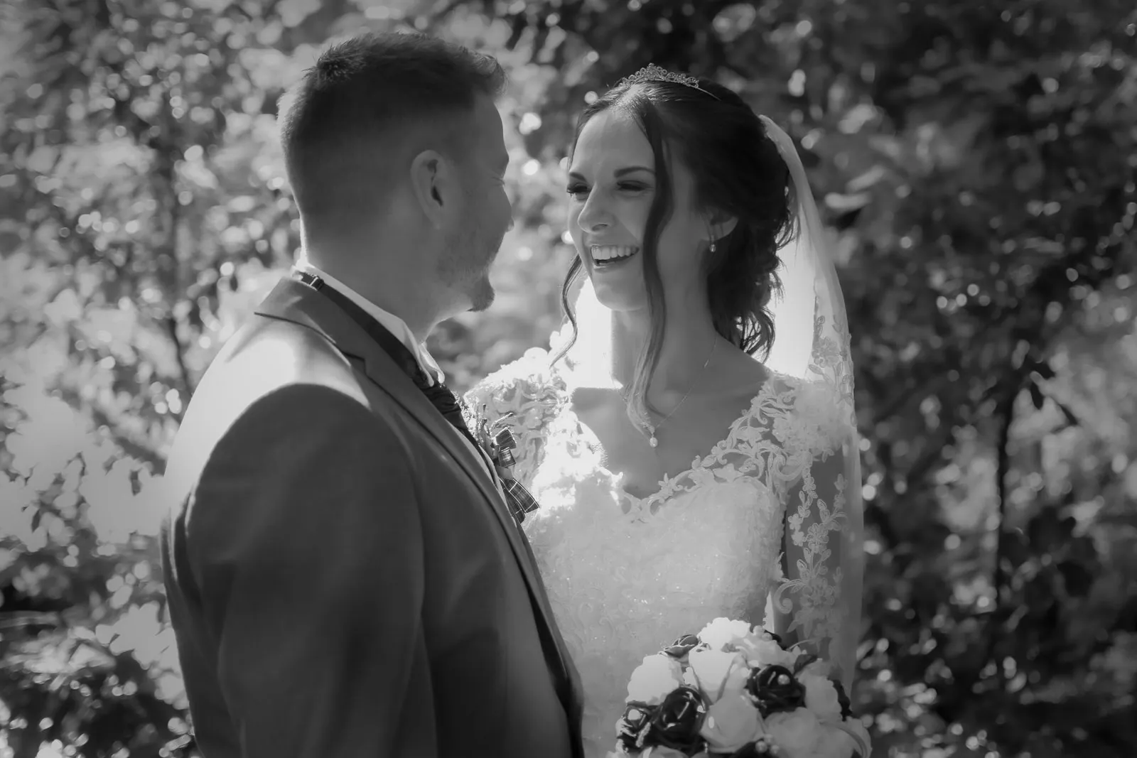 Black and white photo of a bride and groom laughing together at a Lancashire wedding