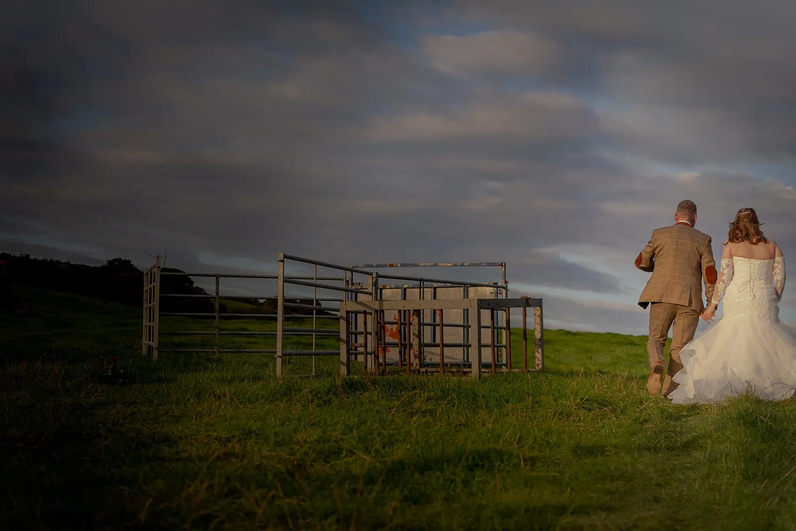Bride and groom walking through the Lancashire countryside at dusk