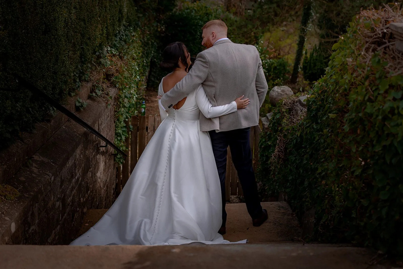 Bride and groom embracing on garden steps at a Lancashire wedding venue