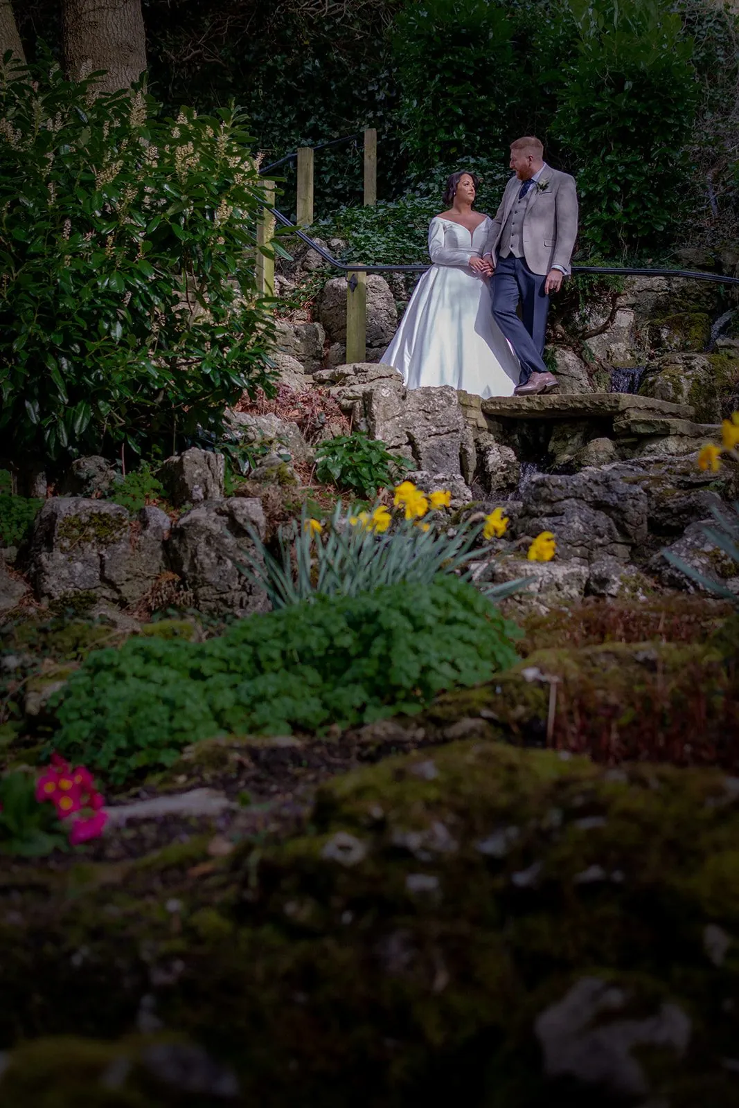 Bride and groom on garden steps surrounded by spring flowers at a Lancashire wedding