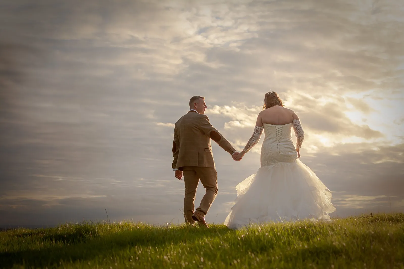 Bride and groom silhouetted at sunset, the kind of open western sky you get west of Garstang